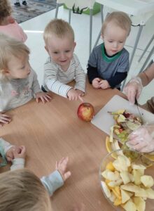 Dzieci pomagają przygotowywać sałatkę w żłobku